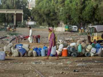 Woman gathers water in Karachi, Pakistan